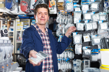 Wall Mural - Smiling worker in hardware store is trading sockets