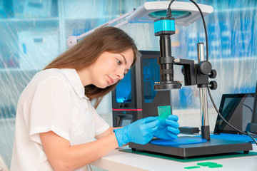 Canvas Print - Woman worker in control of Resin LCD / DLP / SLA 3D Printer in technology lab