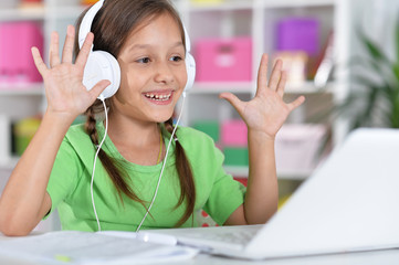 Poster - Portrait of concentrated little girl with laptop studying