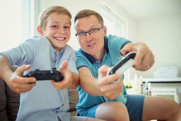 Wall Mural - Happy young father and  his son playing computer games  with controllers very emotional