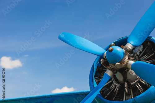Fotomural Close up abstract of a vintage airplane propeller engine against blue sky, closeup