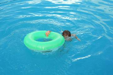 Poster - Little child with inflatable ring in outdoor swimming pool. Dangerous situation