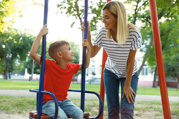 Sticker - Nanny and cute little boy on swing in park