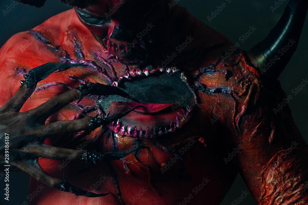 Dark face devil of man on black background. Fantasy red evil or