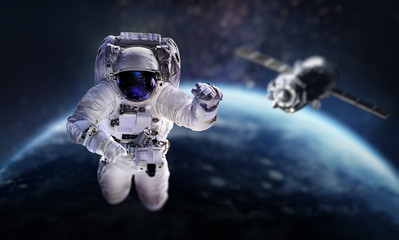 Wall Mural - astronaut in the outer space over the planet earth. space craft behind. spaceship. spaceman. element