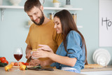 Fototapeta Panele - Young couple cooking together in kitchen