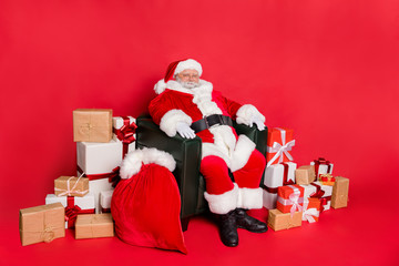 Sticker - Photo of wise glad cute Father Christmas enjoy wait time and kid favorite winter days. Sitting near stack pile many lot wrapped boxes and large bag cap with dreamy presents isolated vivid background