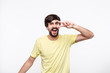 © ianachyrva - Excited brunet bearded man in a yellow t-shirt  with moustaches enjoying music listening songs with wireless headphones and dancing isolated over white background.