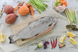 Raw fish for cooking with vegetables on the kitchen table.