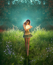 Attractive, Cute Woman Holds The Moon In Her Hands. The Princess Of The Universe In A Short Dress Hugs A Luminous Planet. Walk In A Dream. Green Evening Summer Forest. Fairytale Landscape With Stars