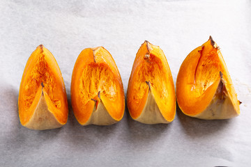 Wall Mural - Pumpkin slices baked in the oven. Roasted pumpkin pieces on a baking tray. Healthy, vegan or vegetarian food.