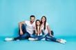 © deagreez - Full length body size photo of family sitting on floor giving you toothy smiles while isolated with blue background