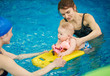 © anatoliy_gleb - Swimming instructor teaching and helping little baby floating in blue water using auxiliary swimming tools for protection. Family healthy active lifestyle, early development, happy childhood concept