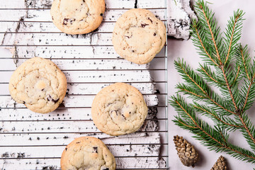 Wall Mural - Ð¡hocolate Chip Cookies on cooling rack and on birch bark decorated fir branches and cones. Fast and easy scandinavian pastry. Cozy winter treat. Hygge. Fika