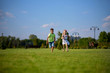 © izikmd - Two happy little kids having fun while running through the grassy field and racing against each other. children running around the green lawn, happy and cheerful, running away to the summer park