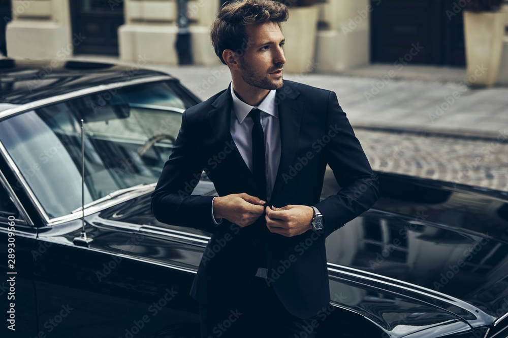 Handsome man in black suit with old classic car - obrazy, fototapety, plakaty 