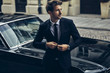 © kiuikson - Handsome man in black suit with old classic car