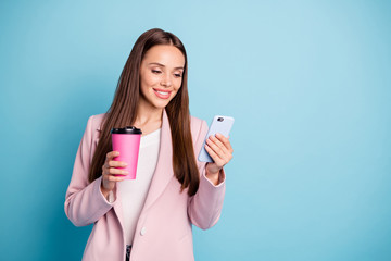 Sticker - Portrait of charming cheerful lady using her cell phone reading news blogs wearing topcoat isolated over blue color background