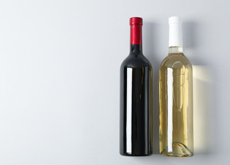 Bottles with wine on grey background, space for text