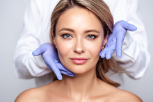 Close Up Portrait Of Young Blonde Woman With Cosmetologyst Hands In A Gloves. Preparation For Operation Or Procedure. Perfect Skin, Spa And Care