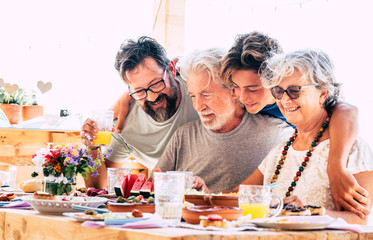 Family group of people with mixed generation have fun together at dinner - friendship and son father grandfathers together with happiness -concept of caucasian diversity ages from young to senior