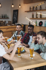 Wall Mural - cheerful multicultural friends celebrating octoberfest together in pub