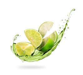 Wall Mural - Sliced lime with splashes of fresh juice close-up on white background