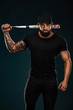 © Mike Orlov - Strong and fit man bodybuilder with baseball bat in black t-shirt. Sporty muscular guy athlete. Sport and fitness concept. Men's fashion.
