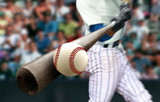 Baseball player hitting ball with bat in close up