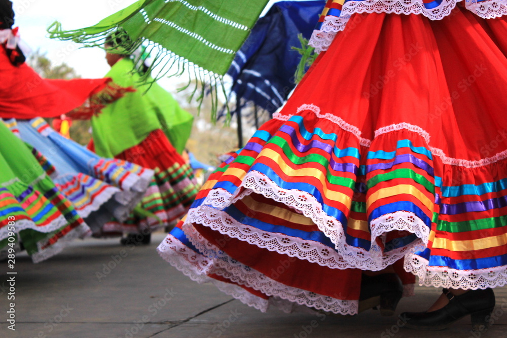 Colorful skirts fly during traditional Mexican dancing - obrazy, fototapety, plakaty 