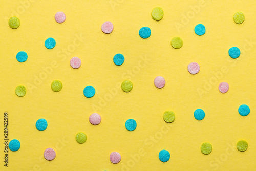 colorful round sprinkles over yellow background, decoration for festive Valen...