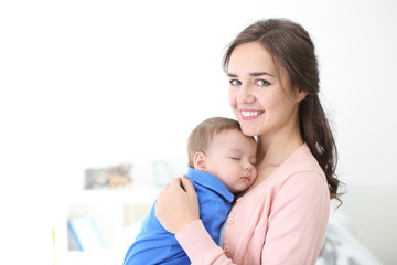 Canvas Print - Loving mother with her baby on light background