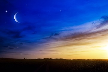Wall Mural - beautiful dark fluffy cloudy sky with sun rays . crescent moon with beautiful sunset background . ge