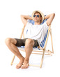 Young man relaxing on sun lounger against white background