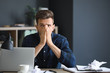 © Pixel-Shot - Stressed young man at table in office