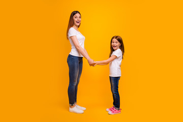 Poster - Full size profile side photo of impressed mom holding her child having long foxy hairstyle screaming wearing white t-shirt isolated over yellow background