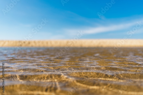 Blur tropical beach with bokeh sun light wave abstract background.