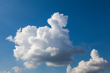 Fototapeta Niebo - White cumulus clouds against a deep blue sky