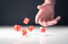 Hand Throwing And Rolling Dice. Gambler Tossing Five Red Poker And Casino Dice On Table. Man Gambling Or Playing Board Game. Risk, Luck, Betting Or Addiction Concept.