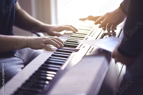 Music lesson and course. Piano teacher and student practising in school. Man learn playing with tutor in class. Two guys training. Mentor teaching pianist. Band practise. Hobby and education concept.