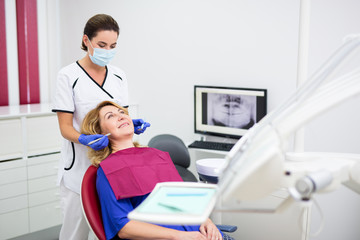 Wall Mural - young dentist with happy mature woman patient at clinic