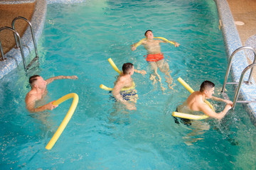 Wall Mural - close up photo of 4 men relaxing in swimming pool in a spa centre