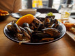 Wide closeup of a bowl of freshly steamed cream mussels at a seafood restauraunt during lunch. St. Ives, England. Travel and Cornish cuisine.