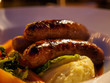 Closeup macro detail of a plate of Bangers and Mash, a traditional dish consisting of fried sausages and mashed potatoes, at a pub. London, England. Travel and cuisine.
