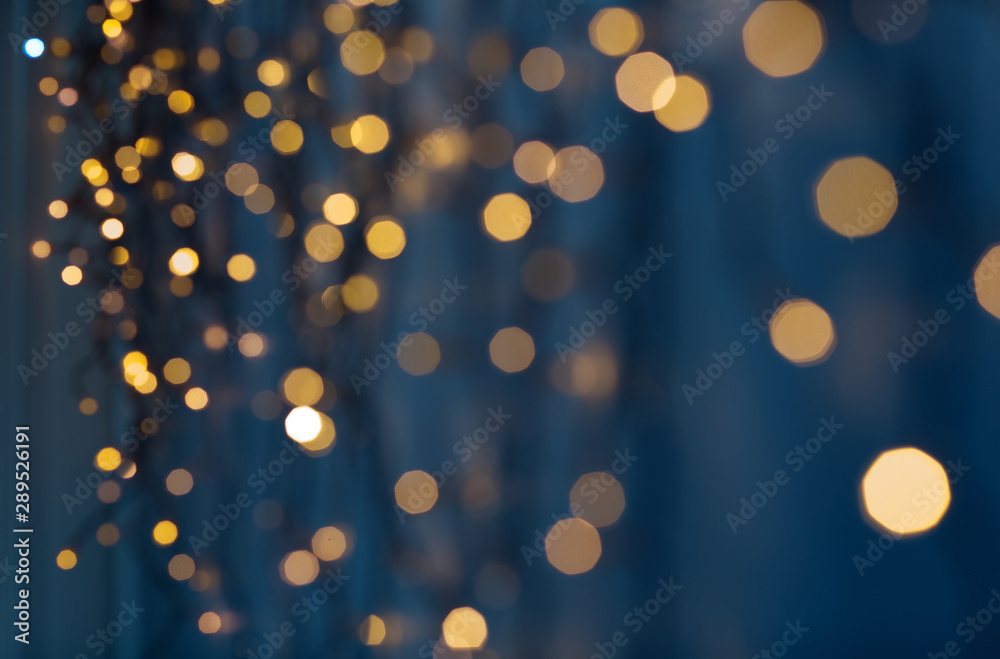holiday, illumination and decoration concept - bokeh of christmas garland lights over dark blue background - obrazy, fototapety, plakaty 