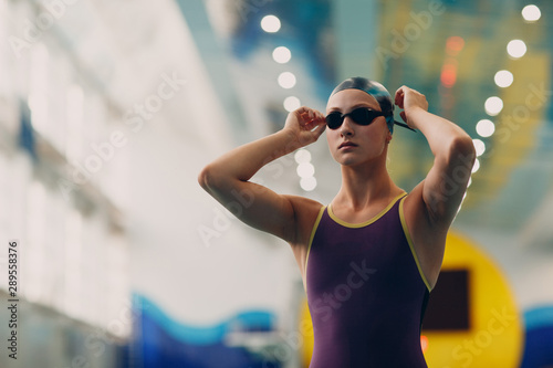 Fotografía Young woman swimmer getting ready for competition and swim in swimming pool