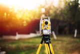 Fototapeta  - surveyor engineering equipment with theodolite and total station in a garden