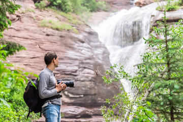 Hays creek falls waterfall in Redstone, Colorado during summer with man photographer standing with camera looking at view