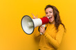 © Asier - Young european woman holding a megaphone smiling cheerfully pointing with forefinger away.
