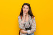 © Asier - Young brunette traveler woman looking sideways with doubtful and skeptical expression.
